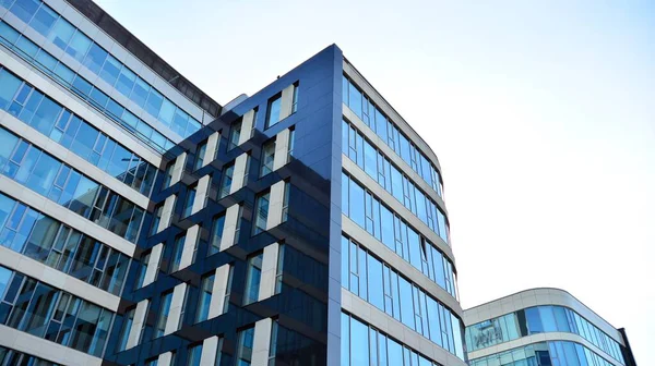 Blue curtain wall made of toned glass and steel constructions under blue sky. A fragment of a building.