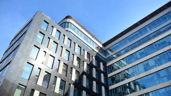 Mavi gökyüzünün altındaki tonlu cam ve çelik yapılardan yapılmış mavi perde duvarı. Bir binanın parçası..