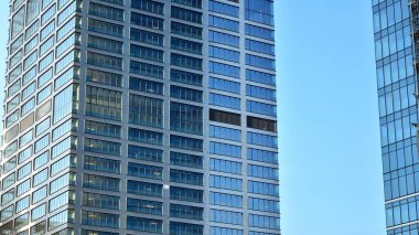 Cam aynalı ofis binasının ön dokusu. Ön cephenin bir parçası. Ofis binasının modern mimarisi.