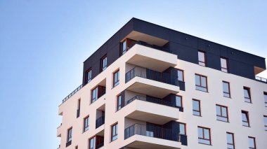 Gündüz gözüyle modern yerleşim yerinin dış tarafında. Mavi gökyüzü olan güneşli bir günde modern apartman binaları. Modern bir apartmanın cephesi