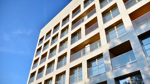 Gündüz gözüyle modern yerleşim yerinin dış tarafında. Mavi gökyüzü olan güneşli bir günde modern apartman binaları. Modern bir apartmanın cephesi