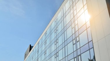 Ofis binası, mavi cam duvar ve güneş yansımalarının detayları..