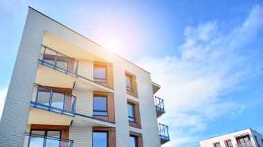 Apartman, ev ve dış görünüş mimarisi ve açık hava tesisleri. Arka planda mavi gökyüzü. Güneş ışığı