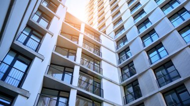 Apartman, ev ve dış görünüş mimarisi ve açık hava tesisleri. Arka planda mavi gökyüzü. Güneş ışığı