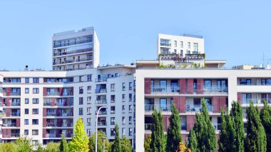 Balkonları ve yeşillikleri olan modern bir apartman. Yazın güzel bir emlak binası manzarası. Ağaçlar ve otlarla dolu bir yürüyüş alanı. Yeşil alandaki modern konut binaları. 