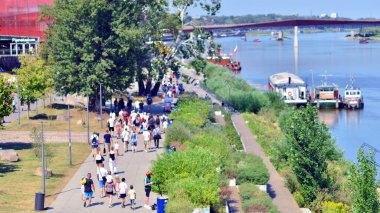 Varşova, Polonya. 15 Ağustos 2025. Vistula nehri boyunca gezinti yapan turistler ve sakinler kalabalıktı. Hafta sonu gezintiye çıkan bir grup insan birlikte yürüyor..