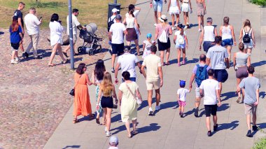 Varşova, Polonya. 15 Ağustos 2025. Vistula nehri boyunca gezinti yapan turistler ve sakinler kalabalıktı. Hafta sonu gezintiye çıkan bir grup insan birlikte yürüyor..