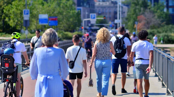 Varşova, Polonya. 15 Ağustos 2025. Swietokrzyski Köprüsü 'nü geçen turistler ve sakinler kalabalıktı. Hafta sonu köprüden birlikte geçen bir grup insan.. 