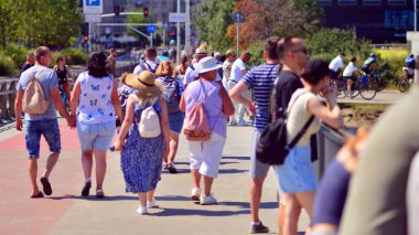 Varşova, Polonya. 15 Ağustos 2025. Swietokrzyski Köprüsü 'nü geçen turistler ve sakinler kalabalıktı. Hafta sonu köprüden birlikte geçen bir grup insan.. 