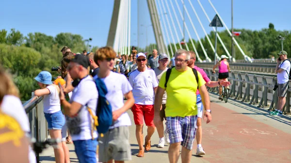 Varşova, Polonya. 15 Ağustos 2025. Swietokrzyski Köprüsü 'nü geçen turistler ve sakinler kalabalıktı. Hafta sonu köprüden birlikte geçen bir grup insan.. 