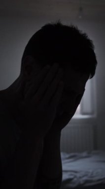 Şiddetli migren ağrısı çeken genç bir adam, karanlık dramatik sahne sağlık sorunu kavramı