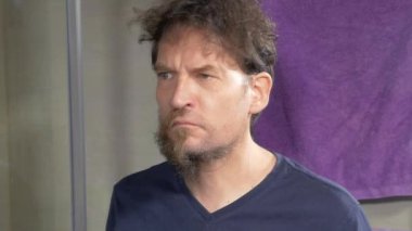 Uzun sakallı adam jilet makinesiyle yakın plan çekiyor.