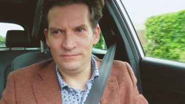 Yakışıklı, zarif, gülümseyen adam eski usul mutlu araba kullanıyor..