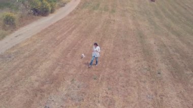 Tarlada çiçek toplayan bir kadının dairesel görüntüsü.