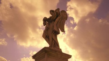 Gün batımında Roma 'nın tarihi merkezi köprüsünde bir melek heykeli.