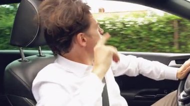 Komik, mutlu, enerji dolu, arabada dans eden adam yakından heyecanlanıyor.