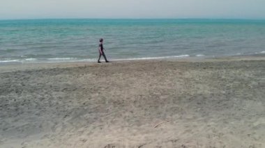 Sabahları okyanus hava atış önünde yürüyen adam