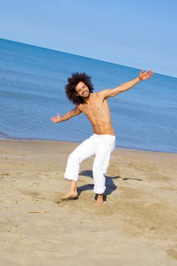 Mutlu adam okyanusun önünde partide eğleniyor