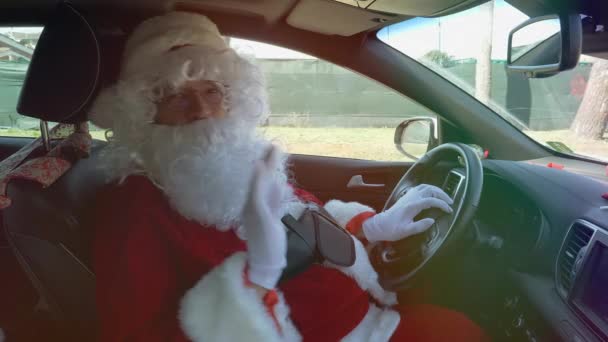 快乐的圣诞老人挥舞着你好标志 同时驾驶汽车中枪 — 图库视频影像
