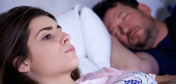 Donna triste al mattino a letto pensando mentre il fidanzato dorme primo piano — Foto Stock