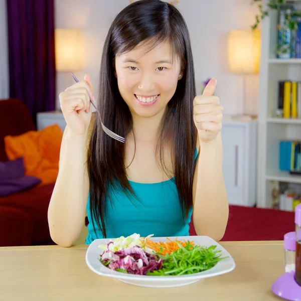 Happy asian woman eating salad at home smiling thumb up — Stock Photo, Image