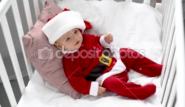gülümseyen bebek beşik evde, yastık Noel kavramı yatan santa kostüm