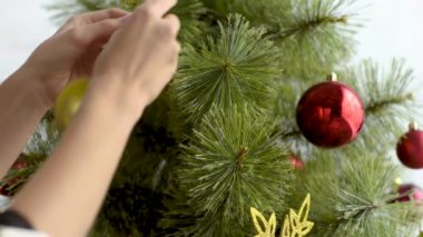 kadın evde topları ile Noel ağacı süsleme görünümünü kırpılmış