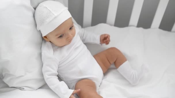 Adorabile Neonato Abiti Bianchi Seduto Culla Gambe Movimento Casa — Video Stock