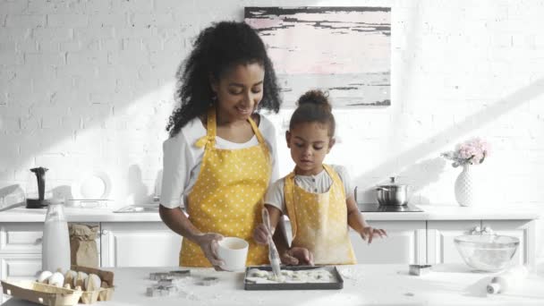 Concentrated African American Kid Apron Brushing Dough Tray While Her — Stock Video