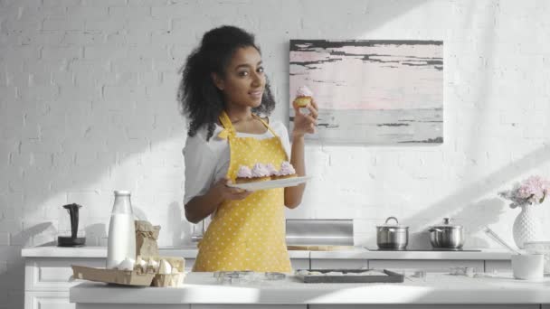 Mulher Americana Africana Alegre Avental Segurando Placa Mostrando Cupcakes Cozinha — Vídeo de Stock