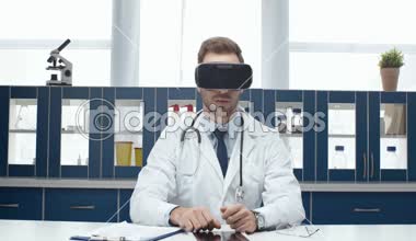 vr kulaklık giyen ve sanal gerçeklik Kliniği karşılaşan beyaz montlu erkek doktor