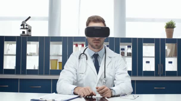 のヘッドセットを着用し クリニックで仮想現実を体験白衣の男性医師 — ストック動画