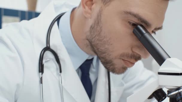 Cientista Masculino Focado Casaco Branco Olhando Através Microscópio Laboratório — Vídeo de Stock