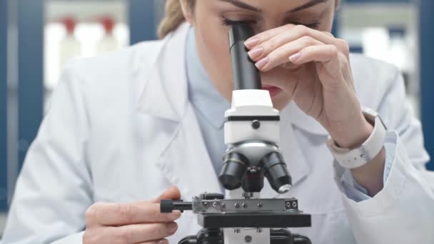 Cientista Fêmea Casaco Branco Olhando Através Microscópio Laboratório — Vídeo de Stock