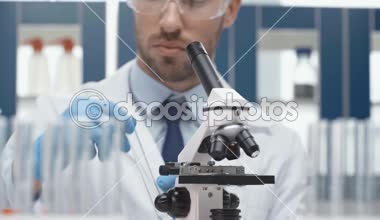 erkek bilim adamı bu durumda laboratuar mikroskobu aracılığıyla seyir gözlük