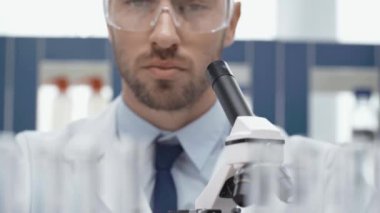 erkek bilim adamı bu durumda laboratuar mikroskobu aracılığıyla seyir gözlük