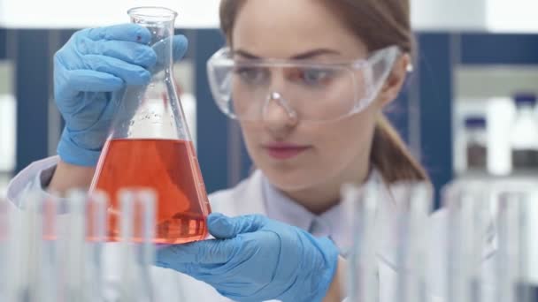 Female Scientist Goggles Holding Flask Red Liquid Experiment Laboratory — Stock Video