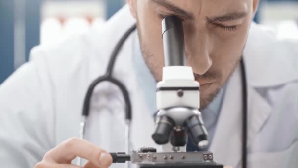 Enfoque Selectivo Del Científico Masculino Que Mira Través Del Microscopio — Vídeo de stock