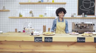 güzel gülümseyen Afrikalı-Amerikalı kadın Kafe sahibi tatlılar tezgahın arkasındaki dans önlük