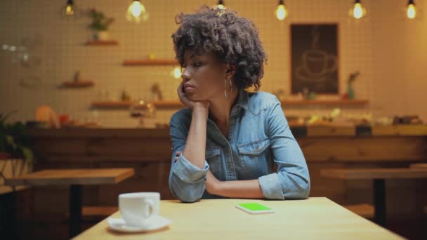 カフェで誰かを待っている間手であごを支え美しい悲しいアフリカ系アメリカ人女性客 — ストック動画