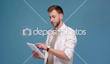 Dijital tablet kullanarak ve üzerinde izole mavi gülen adam