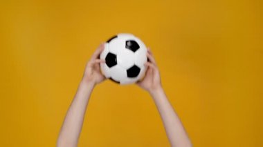 adam sunulması ve sarı izole hava futbol topu atma kırpılmış görünümü