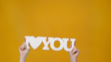 'seni seviyorum' işareti sarı izole gösteren kadın kırpılmış görünümünü
