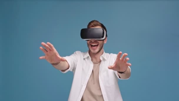 仮想現実のヘッドセットの手でジェスチャーと笑顔で分離された青の男 — ストック動画