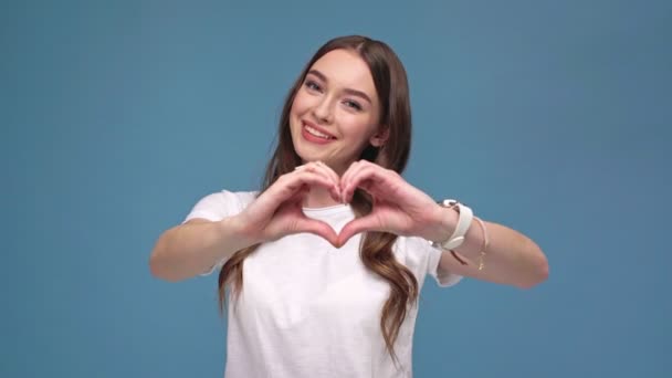Красивая Улыбающаяся Девушка Показывающая Знак Форме Сердца Сделанный Руками Смотрящая — стоковое видео