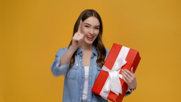Schöne Mädchen Zeigt Mit Dem Finger Auf Geschenkbox Lächelt Blickt — Stockvideo