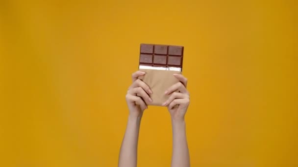 Обрезанный Вид Женщины Представляющей Шоколад Изолирован Желтый — стоковое видео
