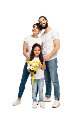 happy latin parents standing near cute daughter with flowers isolated on white  clipart