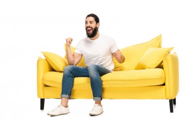 sakallı latin adam kanepede otururken şampiyonluk izlerken ve beyaz izole zafer kutluyor 