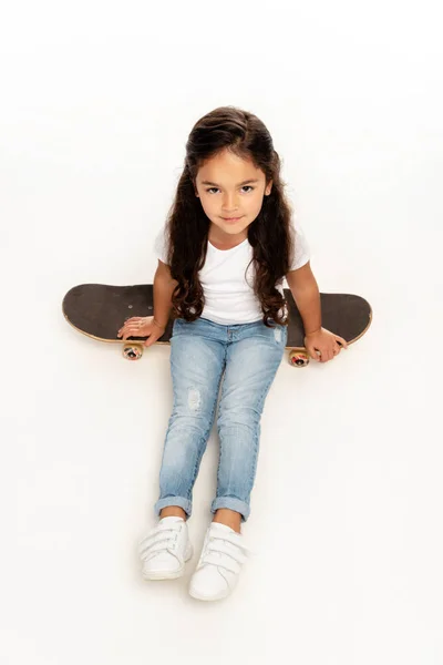 Overhead View Cute Latin Kid Sitting Penny Board Isolated White — Stock Photo, Image